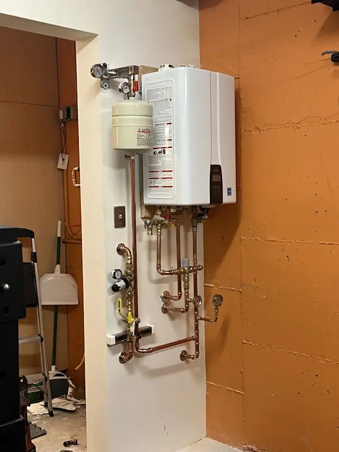 Plumbing technician inspecting water heater connections in Rosewood Heights